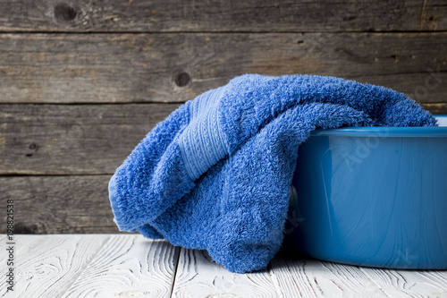 blue towel in basin on the table on wooden background