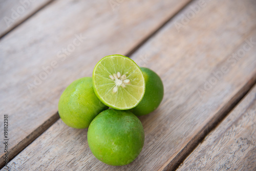 Fresh green lemon on wood table.