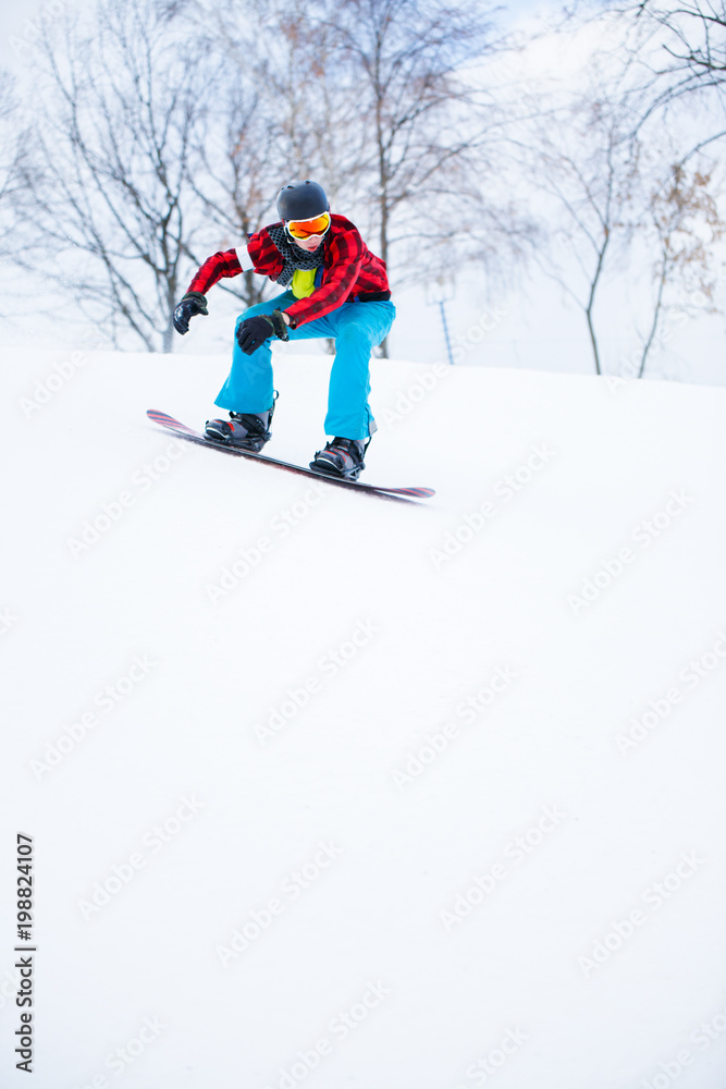 Picture of athlete in helmet with snowboard riding in snowy resort Picture of athlete in helmet with snowboard riding in snowy resort