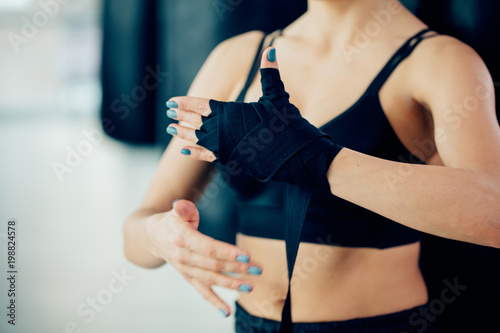 cropped photo of binging bandage on woman's hand. training with blue nails. prevent injuries. protection. safe trainings