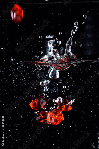 drop of red stones into the water with a spray