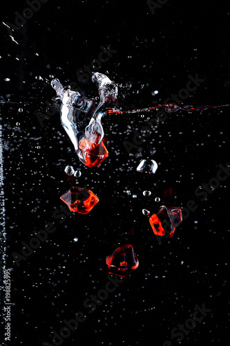 drop of red stones into the water with a spray