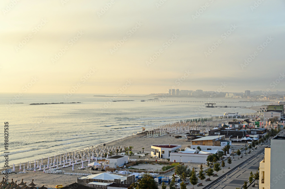 Beach of Black Sea from Mamaia, Romania with golden sands, sun umbrellas, sunbeds, blue clear water, bars and hotels
