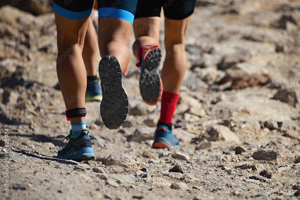 Trail running group on mountain path exercising,freeze action closeup of running shoes in action