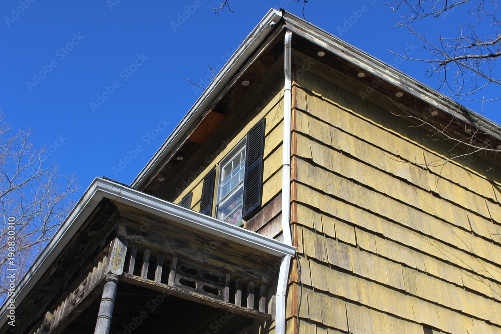 Historic New England house in disrepair with faded and chipped paint Historic New England house in disrepair with faded and chipped paint