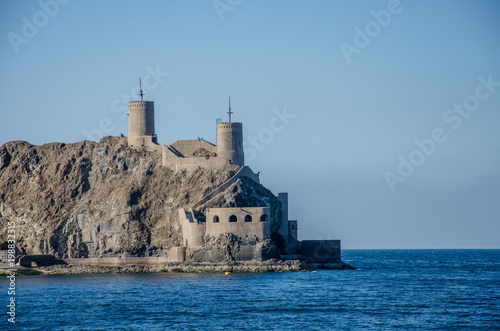 Old fort towers on rocky cliff above ocean