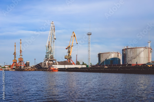 Port of a large Russian city with ships and various equipment on the background of the river.