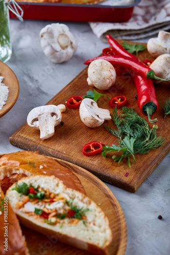 Countryside cuisine still life with pie, vegetable and herbs on cutting board over white background, selective focus.