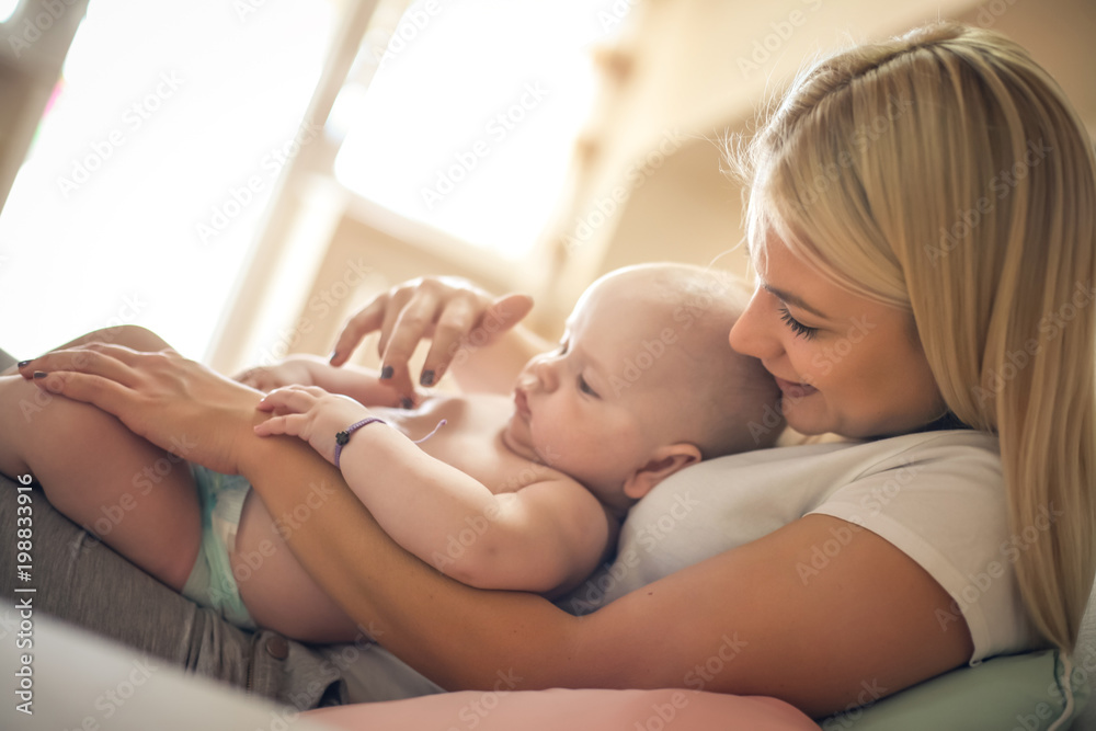 Smiling mother playing with her baby boy at home. Smiling mother playing with her baby boy at home.
