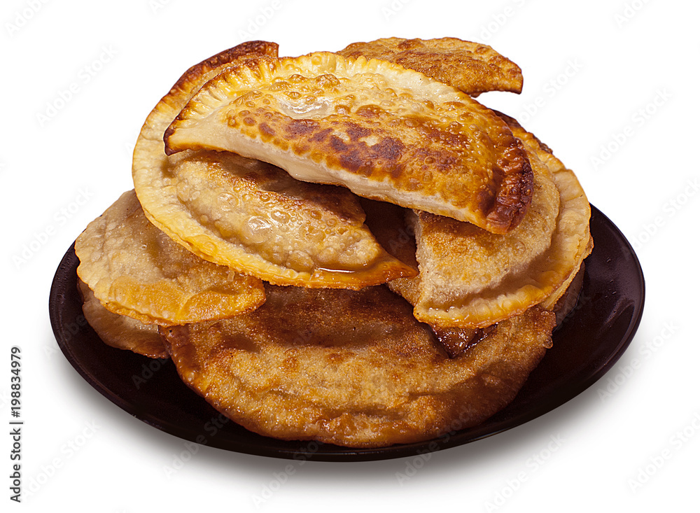 Fried chebureks on plate on white isolated background.