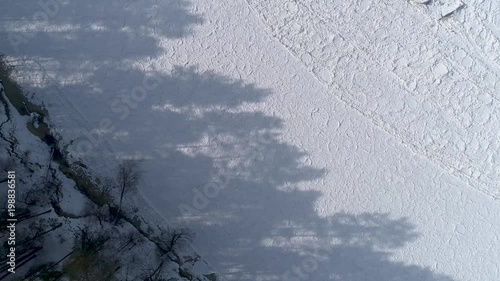 Shadow of trees on frozen River, Overhead drone footage photo