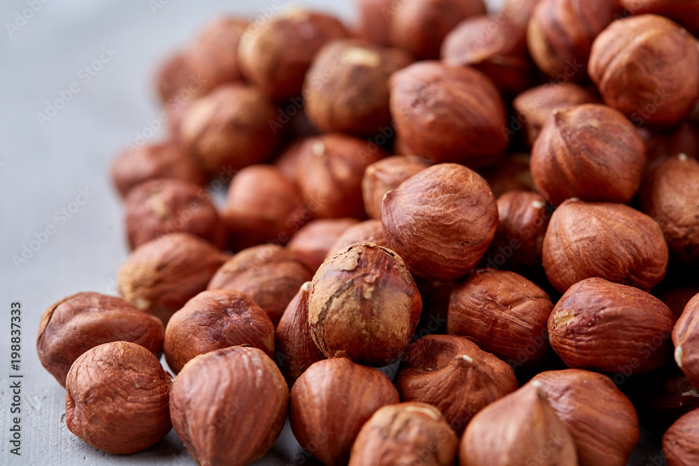 Raw hazelnut on heap isolated on white background, selective focus, shallow depth of field Raw hazelnut on heap isolated on white background, selective focus, shallow depth of field