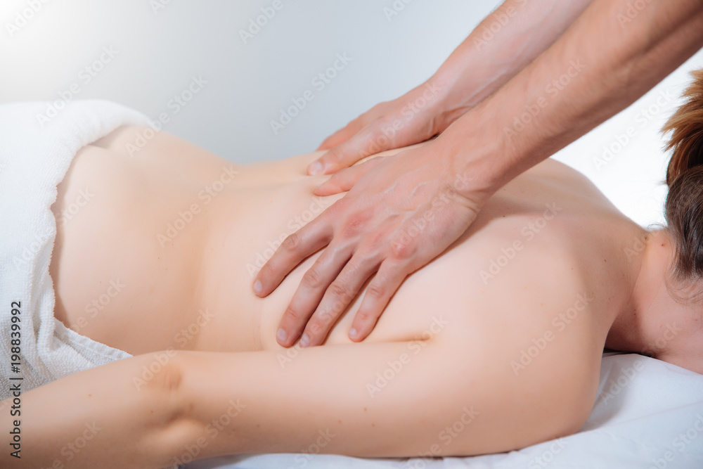 doctor massaging the back of a young woman doctor massaging the back of a young woman