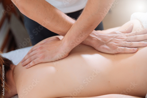 doctor massaging the back of a young woman