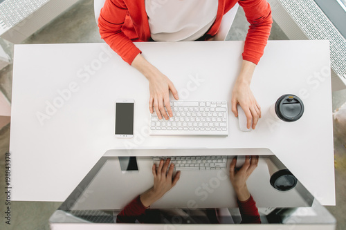 high angle cropped shot of student typing on keyboard while working on computer photo