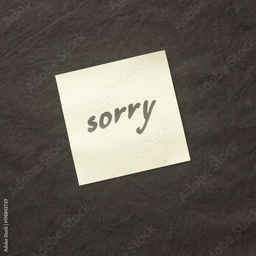 Handwritten note on a dark background. Note of apology- Sorry, please forgive me.