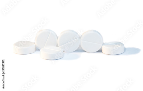 Several pills lying on a white background or on a medical book with graphs
