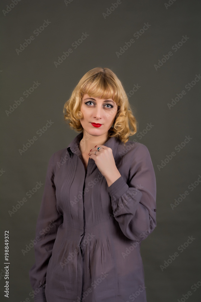 A woman with blond hair dressed in a gray shirt. Posing in the Studio on a gray background.
A woman with blond hair dressed in a gray shirt. Posing in the Studio on a gray background.