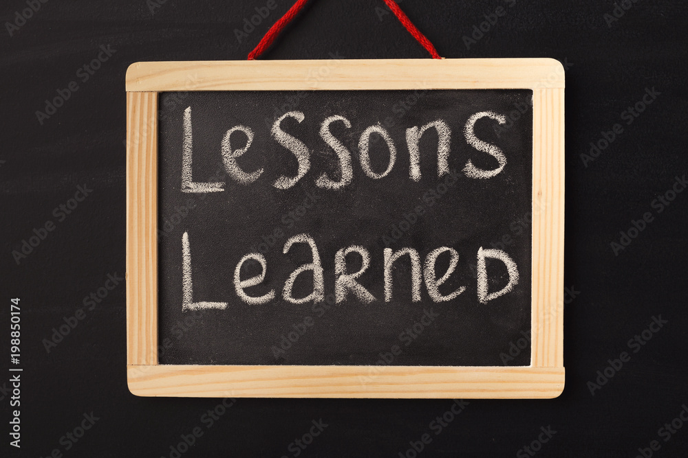 Fotografie Word lessons learned written on miniature chalkboard