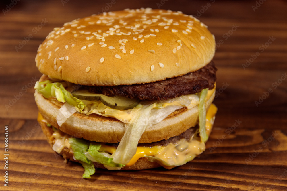 Delicious big hamburger on wooden table Delicious big hamburger on wooden table