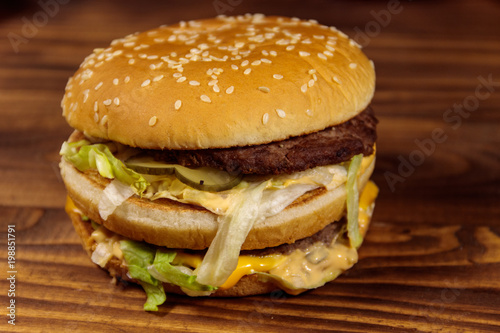 Delicious big hamburger on wooden table © olyasolodenko