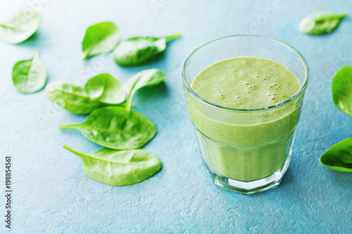 Green spinach smoothie in glass for healthy breakfast.