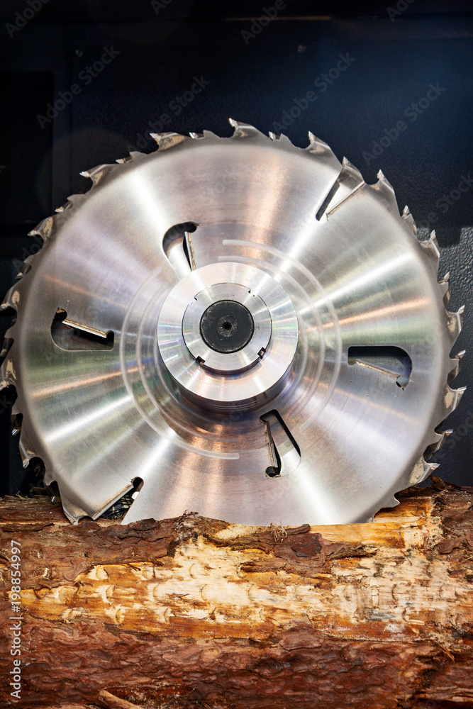 Sawmill. Powerful circular saws saw a log. Sawmill. Powerful circular saws saw a log.