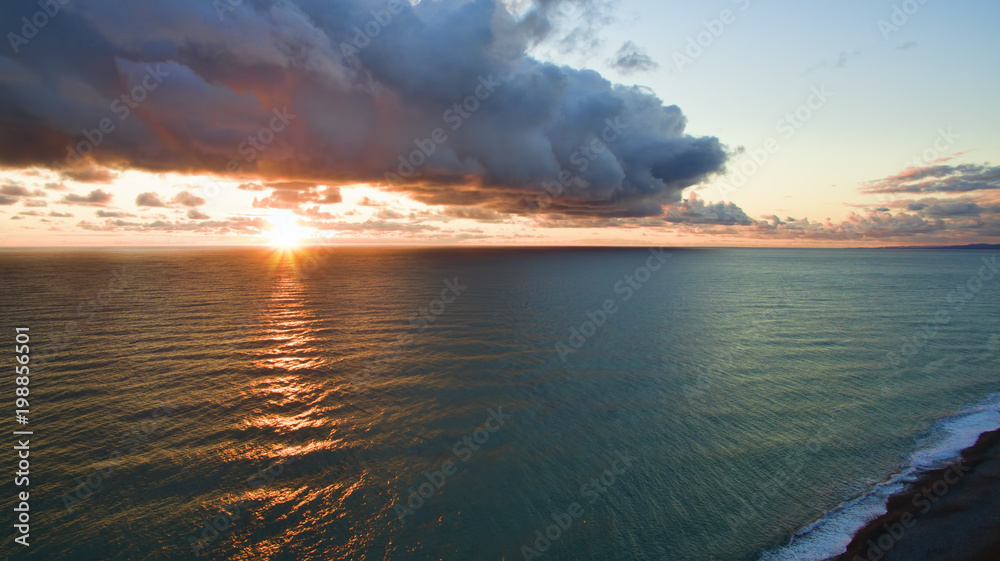 Sea landscape with dramatic sunset views and a large cloud.