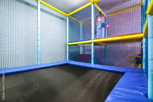 Fotografie Colorful plastic jungle for kids with trampoline indoor