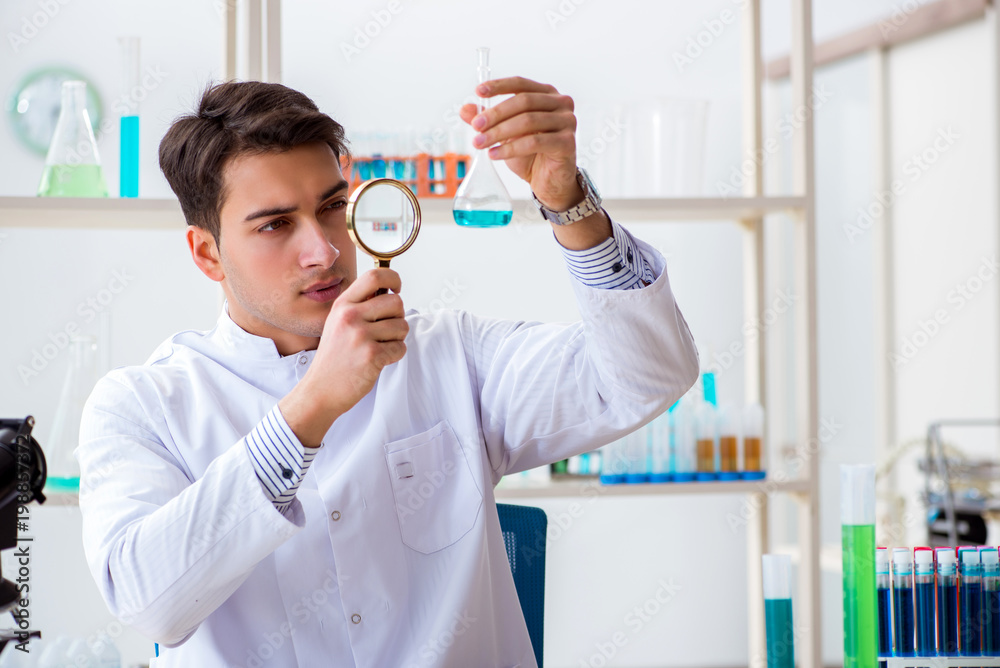 Naklejka premium Young chemist student working in lab on chemicals
