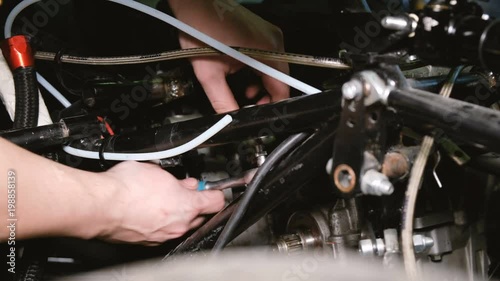 The team of car mechanics removes the internal combustion engine from the race car. photo