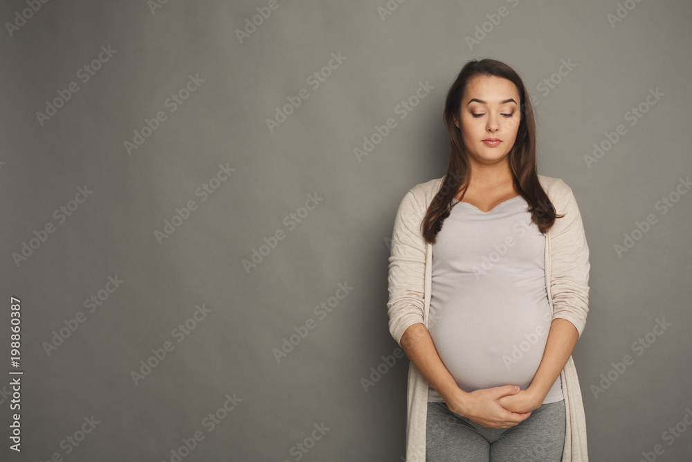 Pregnant woman with closed eyes at studio Pregnant woman with closed eyes at studio