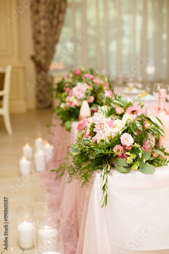 Details of decoration of Groom s and Bride s wedding table on wedding party. Decoration by pink fabric and flowers. Bonbonnieres with honey for guests