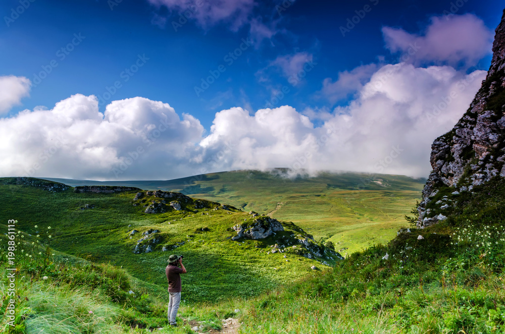 Obraz premium Male hiker akes photos in alpine mountains