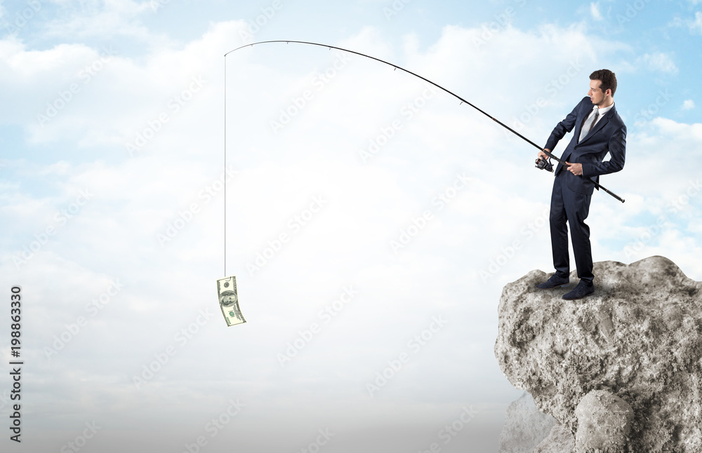 Elegant young businessman fishing cash from a huge rock Elegant young businessman fishing cash from a huge rock