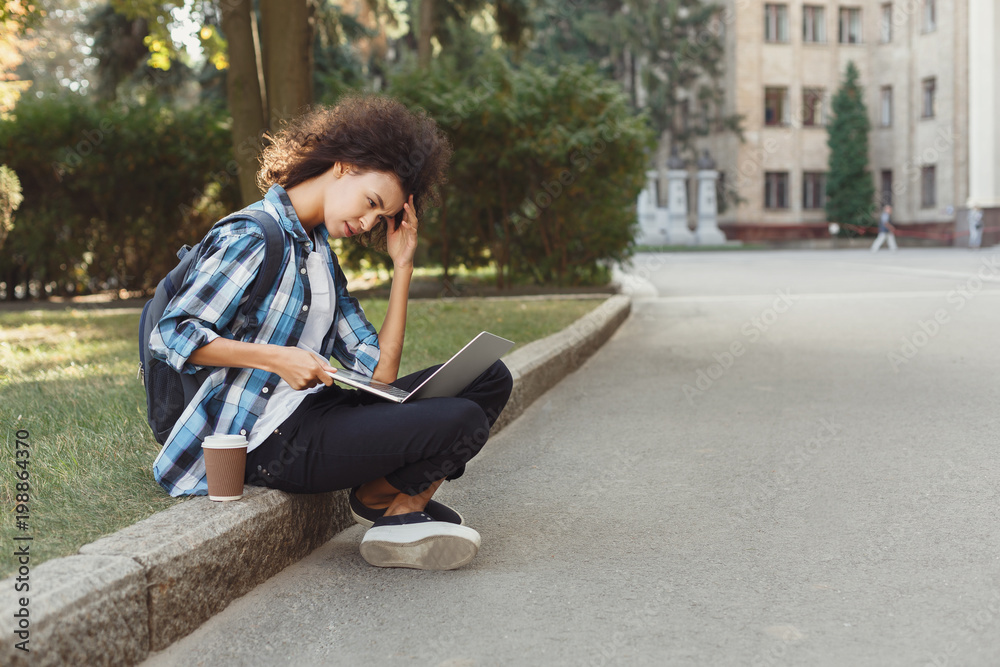 Obraz premium Young woman using laptop at university