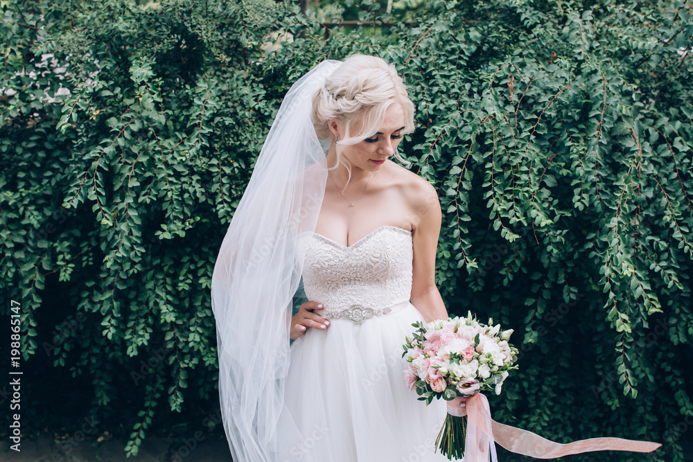 A bride in a white dress is holding a beautiful wedding bouquet. A bride in a white dress is holding a beautiful wedding bouquet.