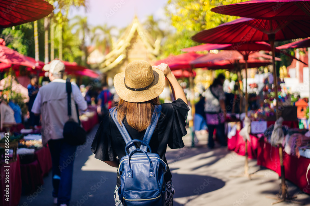 Obraz premium Young woman traveler traveling to Wat Phra Singh temple. This temple contains supreme examples of Lanna art in the old city center of Chiang Mai,Thailand.
