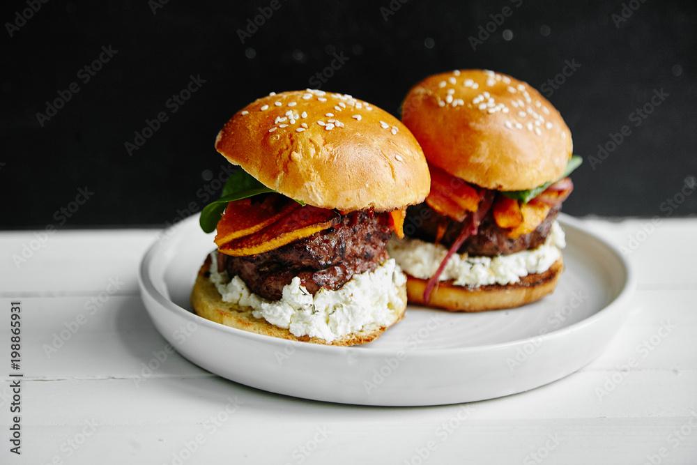 Burgers with grilled beef patties, cream cheese and spinach on classical bun. Burgers with grilled beef patties, cream cheese and spinach on classical bun.