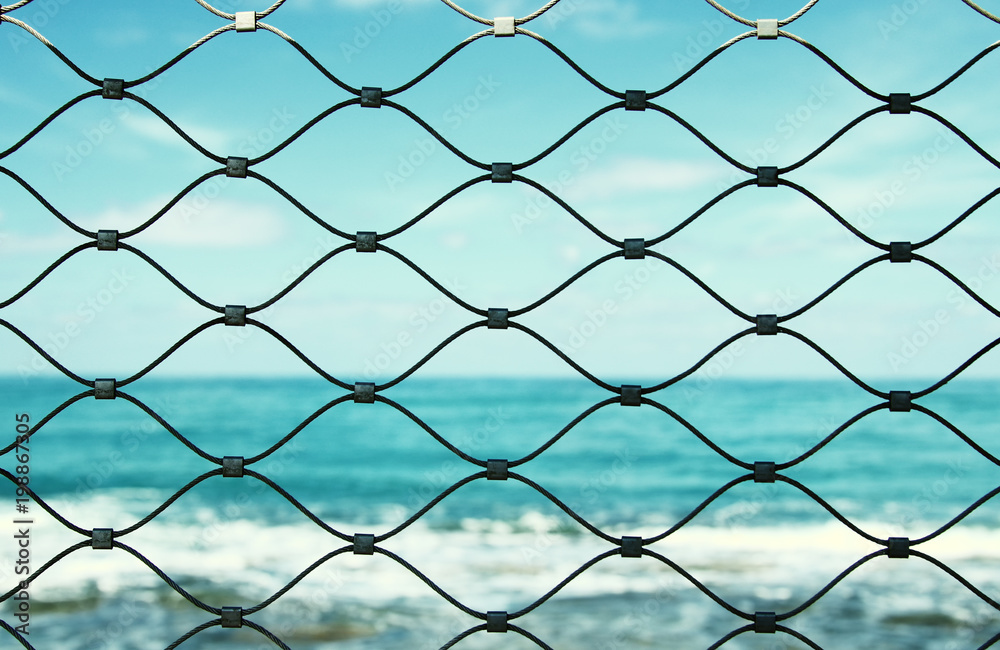Barbed wire - restricted area and sea in the horizon. Barbed wire - restricted area and sea in the horizon.