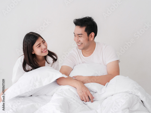 Happy Asian couple on bed and looking together. © nuiiko