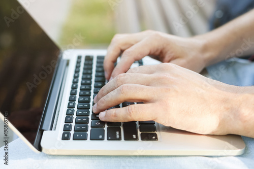 Male hands with laptop closeup outdoors © Prostock-studio