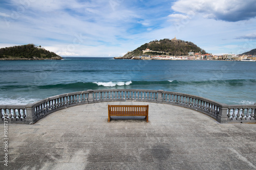 beautiful view on monte urgull from shore place with bench, relaxing moments in san sebastian, basque country, spain