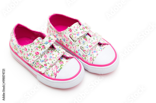 Girls' shoes in flowers and pink color on a white background. Flat lay