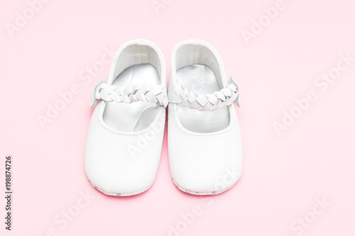 Shoes for the little girl of white color on pastel background. Fashion