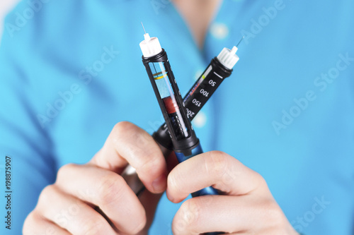 Wallpaper Mural Hand holding insulin pen on white background Torontodigital.ca