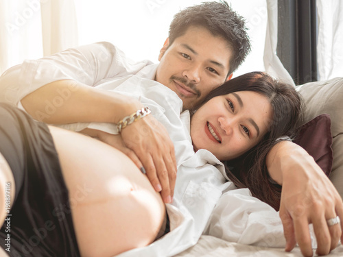 pregnant girl hugging from behind male hands behind tummy.beautiful pregnant woman and her handsome husband hugging the tummy.