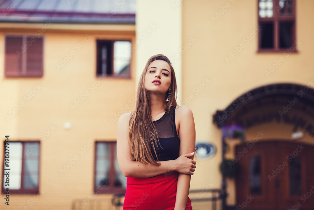 Portrait of young girl with beautiful eyes outdoors. Woman in urban background.