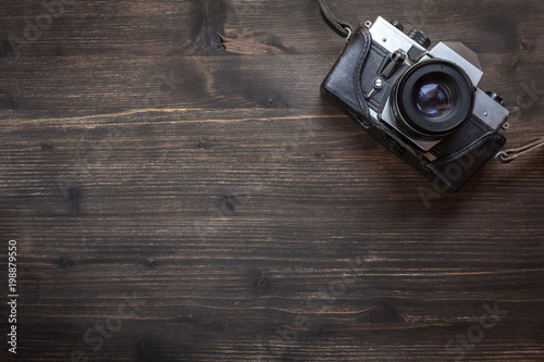 Old retro camera on wooden table background