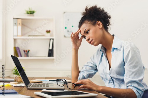 Frustrated business woman with headache at office photo